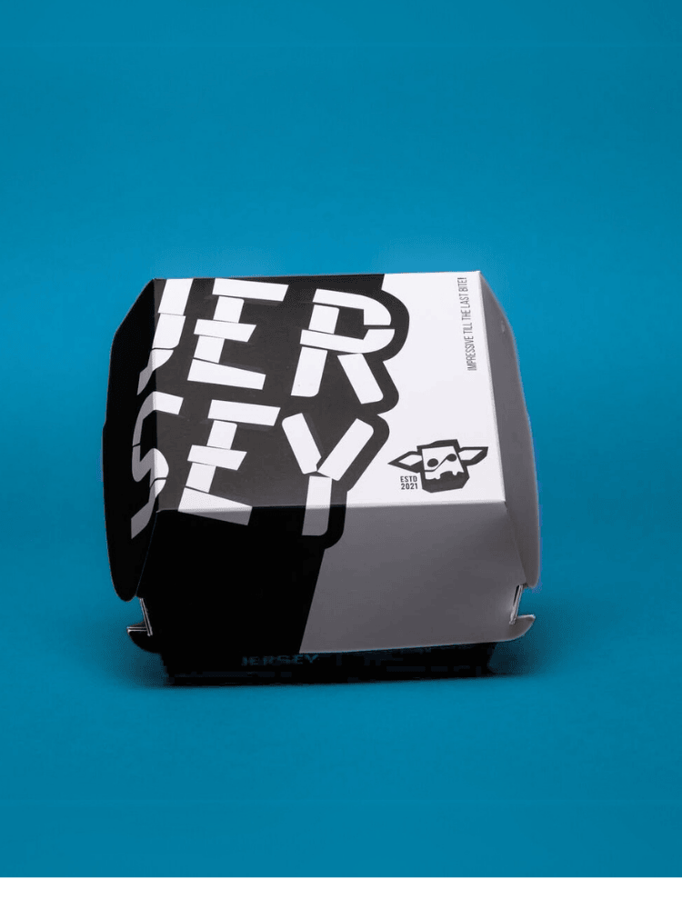 Closed black and white burger box with bold text on a blue background.