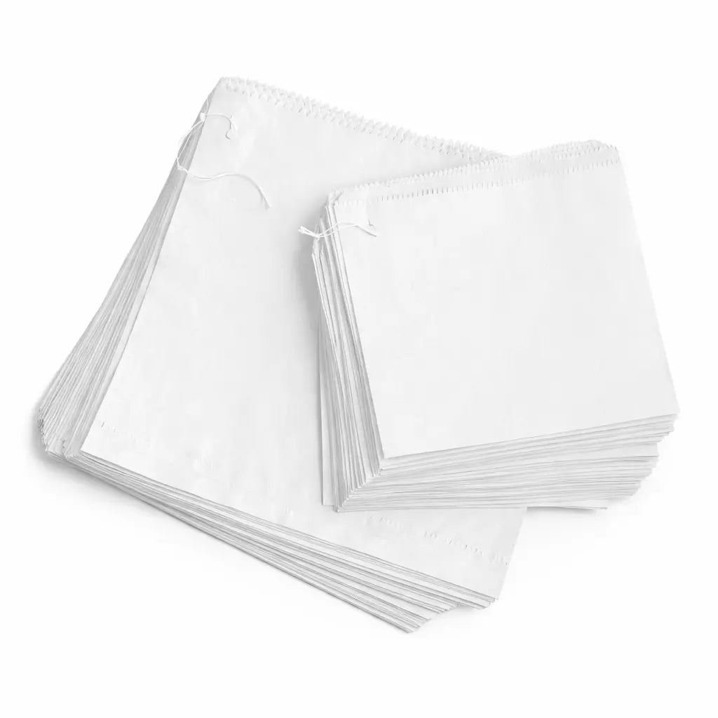 Two stacks of White Greaseproof Paper Bags 6" (900 Pack), one larger and one smaller, are placed side by side on a white background.