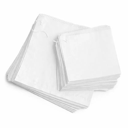 Two stacks of White Greaseproof Paper Bags 6" (900 Pack), one larger and one smaller, are placed side by side on a white background.